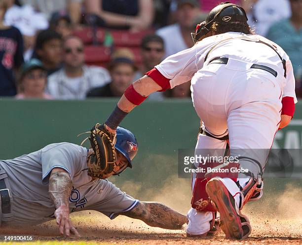 Toronto Blue Jays player Brett Lawrie scores from second base on a single by Colby Rasmus as Boston Red Sox catcher Jarrod Saltalamacchia tries to...