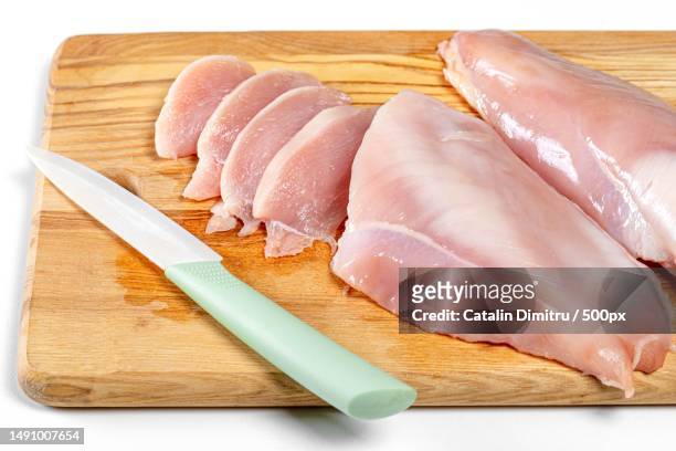raw chicken fillet on wooden kitchen board with knife,romania - knife block stock-fotos und bilder