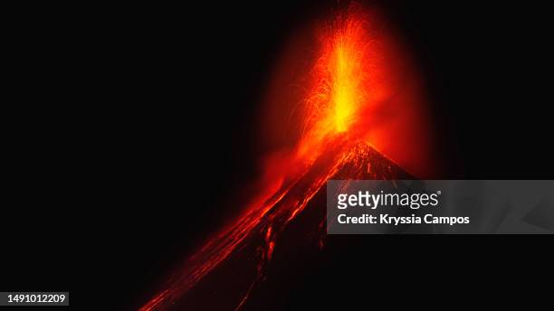 volcano erupting lava on a dark night - active volcano stockfoto's en -beelden