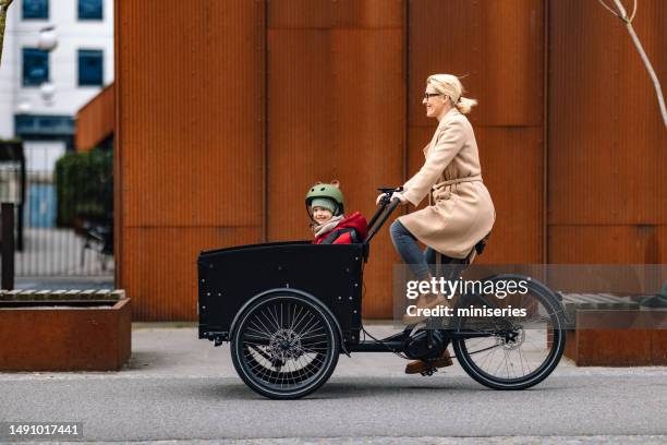 happy mother riding a cargo bike with her little girl in the city - cykelbana bildbanksfoton och bilder