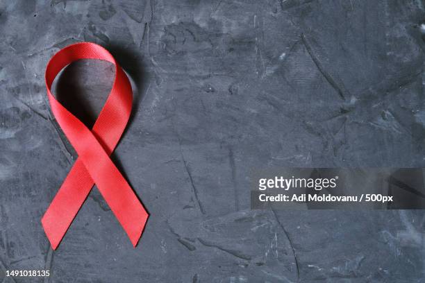red ribbon on concrete texture background,symbol of aids disease and drug abuse problem,romania - hiv stock-fotos und bilder