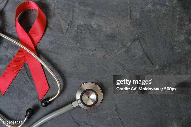 red ribbon symbol of aids,drug abuse problem,stethoscope on concrete texture background,romania - hiv prevention stock pictures, royalty-free photos & images