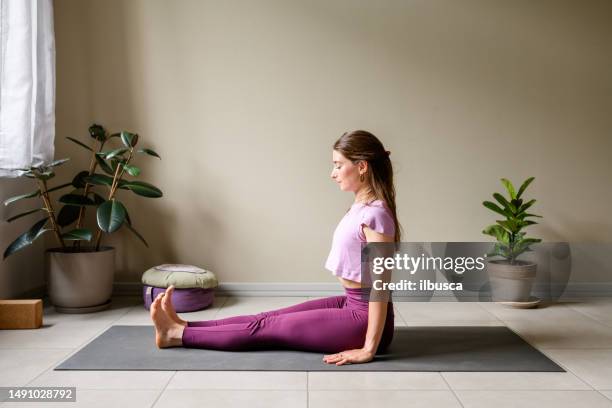 professional woman practicing yoga at home: staff, dandasana - shepherds staff stockfoto's en -beelden