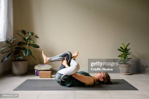 professional woman practicing yoga at home - lying on back stock pictures, royalty-free photos & images