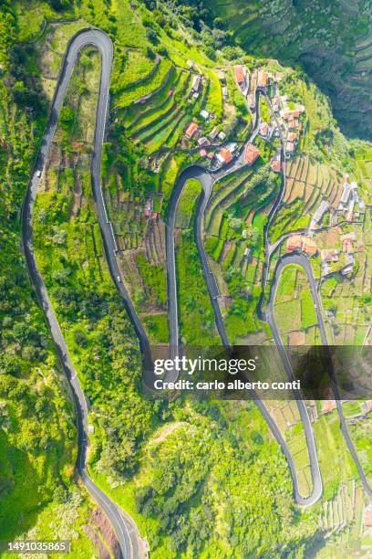 aerial vertical view of the mountain road in madeira island during a sunny spring day, porto moniz, madeira, portugal, europe - madeira material stock-fotos und bilder