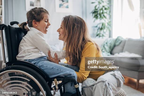 mother and young daughter at home - rolstoel stockfoto's en -beelden