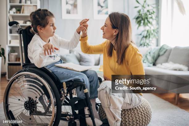 mom and young daughter having fun - special needs children stock pictures, royalty-free photos & images