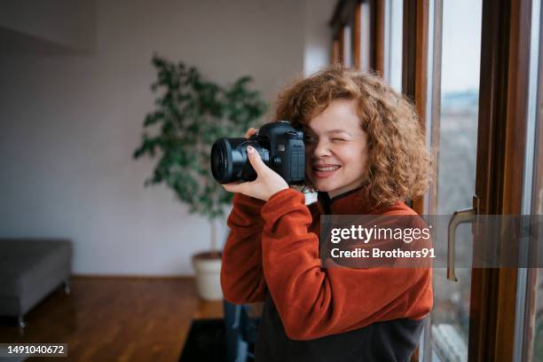 woman photographer working in home studio testing her new dslr camera - camera picture stock pictures, royalty-free photos & images