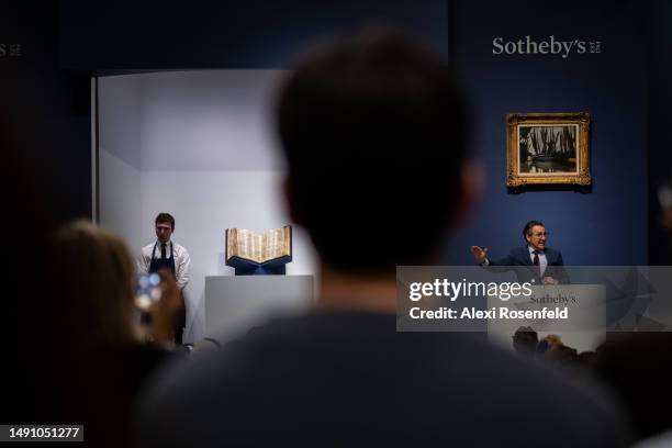 People watch as auctioneer Benjamin Doller, takes bids for The Codex Sassoon during the auction at Sotheby's on May 17 , 2023 in New York City. The...