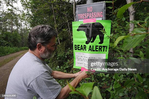 Property owner Kevin Stevens posts a notice about a bear attack on a private trail above Eagle River Road in Anchorage, Alaska. High up in the brush...