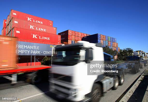 Truck drives past Kawasaki Kisen Kaisha Ltd. "K" Line shipping containers at the Port of Fremantle in Perth, Australia, on Friday, July 20, 2012....