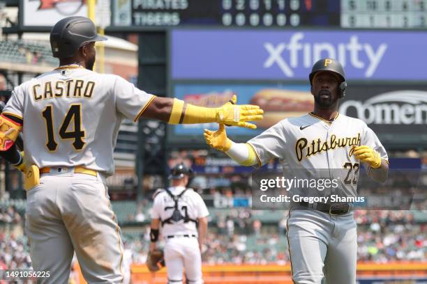 Andrew McCutchen of the Pittsburgh Pirates celebrates scoring a seventh inning run with Rodolfo Castro while playing the Detroit Tigers at Comerica...