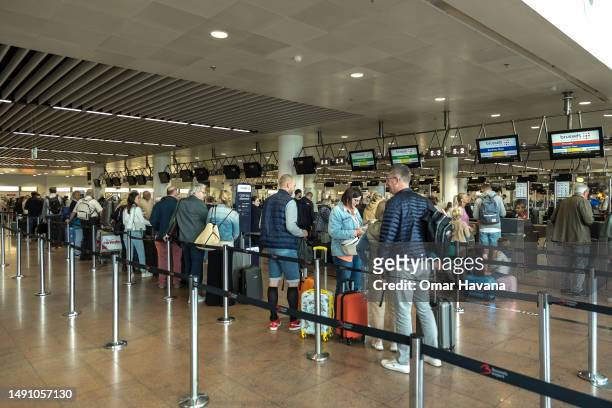 Passengers queue for check-in for Brussels Airlines flights at the airport in the Belgian capital on May 17, 2023 in Brussels, Belgium. Brussels...
