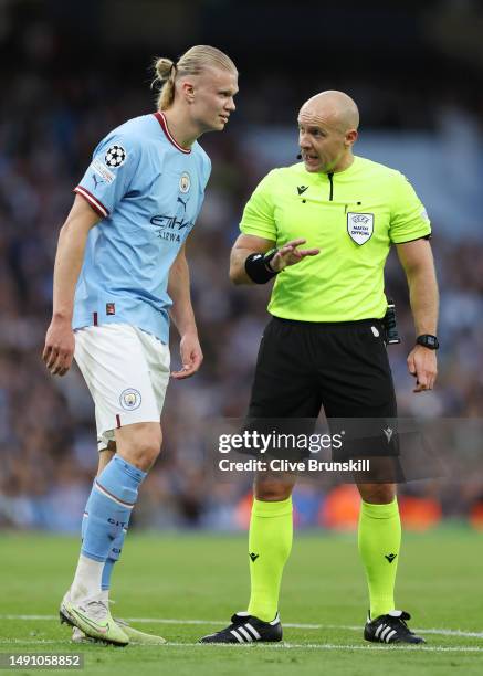 Referee Szymon Marciniak speaks to Erling Haaland of Manchester City during the UEFA Champions League semi-final second leg match between Manchester...