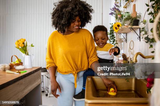 playing with bath duck in the kitchen sink - 3 little black ducks stock pictures, royalty-free photos & images