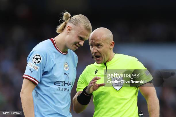 Referee Szymon Marciniak speaks to Erling Haaland of Manchester City during the UEFA Champions League semi-final second leg match between Manchester...