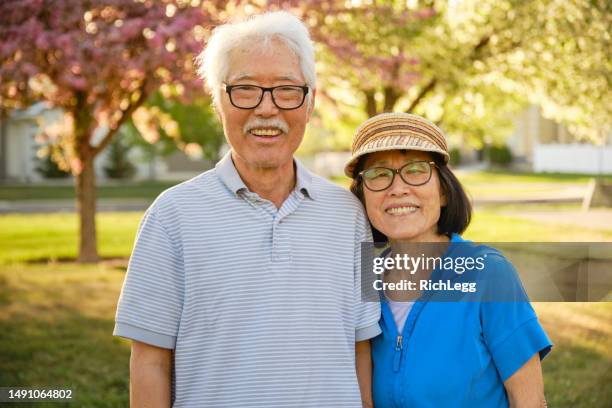 senior aged couple spending time together in a park - korean ethnicity stock pictures, royalty-free photos & images