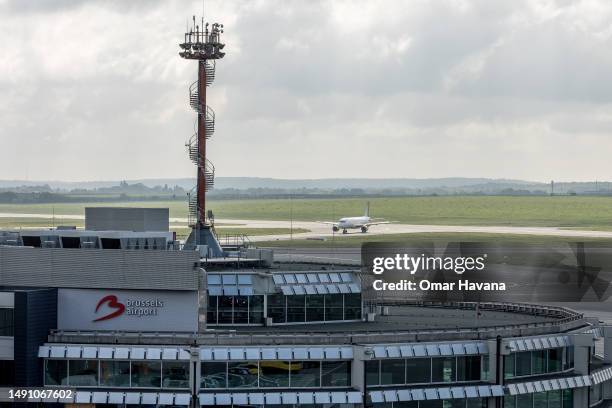 Plane from the Spanish airline Vueling taxis to its designated arrival gate behind the offices of Brussels airport on May 17, 2023 in Brussels,...