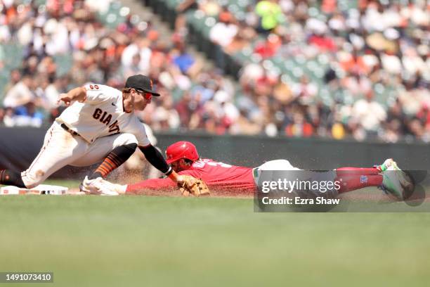 Bryce Harper of the Philadelphia Phillies slides safely past Casey Schmitt of the San Francisco Giants at third base for a stolen base in the fourth...