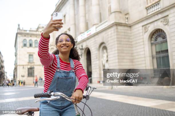 young woman with a bicycle using smart phone and taking selfie - tourist selfie stock pictures, royalty-free photos & images