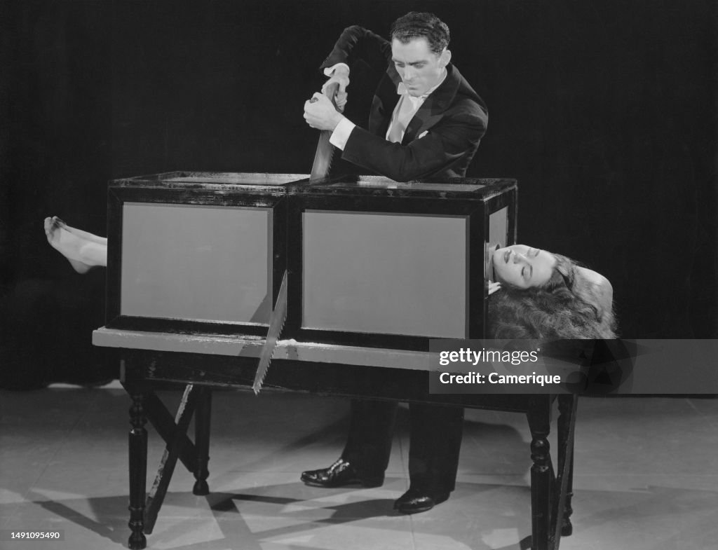 Magicians Box Table Male magician performing on stage with a woman inside of a box on the ...