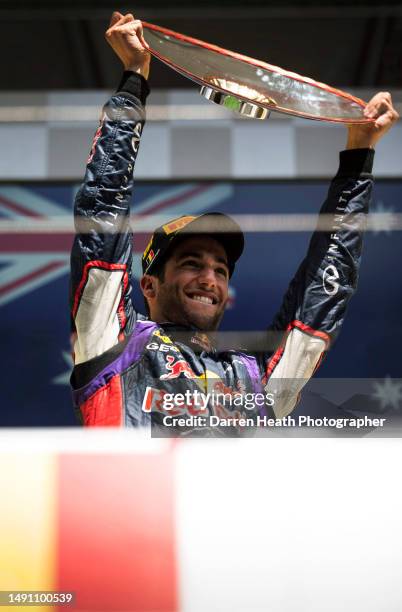 Smiling Australian Red Bull Racing Formula One racing team racing driver Daniel Ricciardo holding the Shell Petroleum logo adorned race winning...