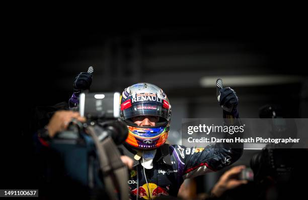 Australian Red Bull Racing Formula One racing team racing driver Daniel Ricciardo raising his arms and clenching his fists while wearing his logo...