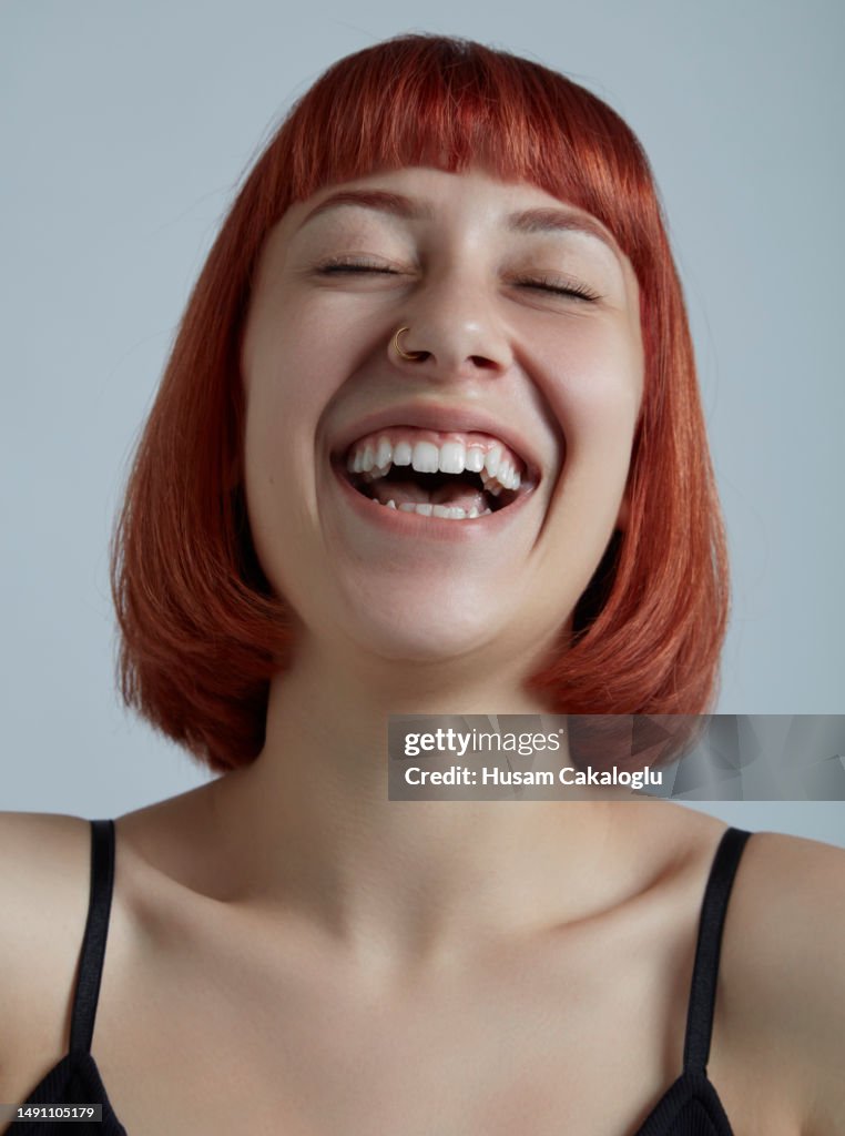 Portrait of young woman with red and bob cut hair.