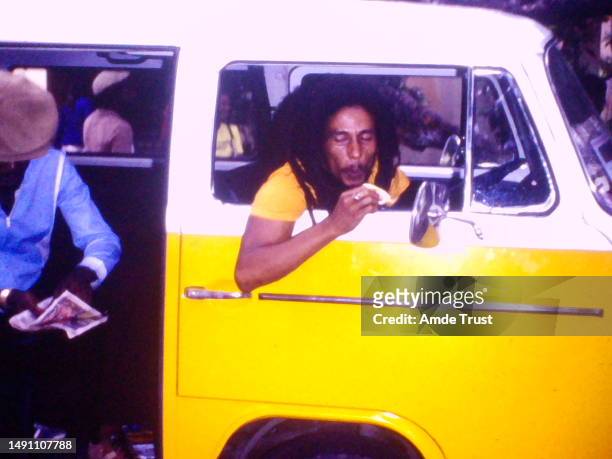 Reggae singer Bob Marley eating fruit before speaking with Fr. Amde Hamilton at Tuff Gong studio in Jamaica circa 1978 in Jamaica West Indies.