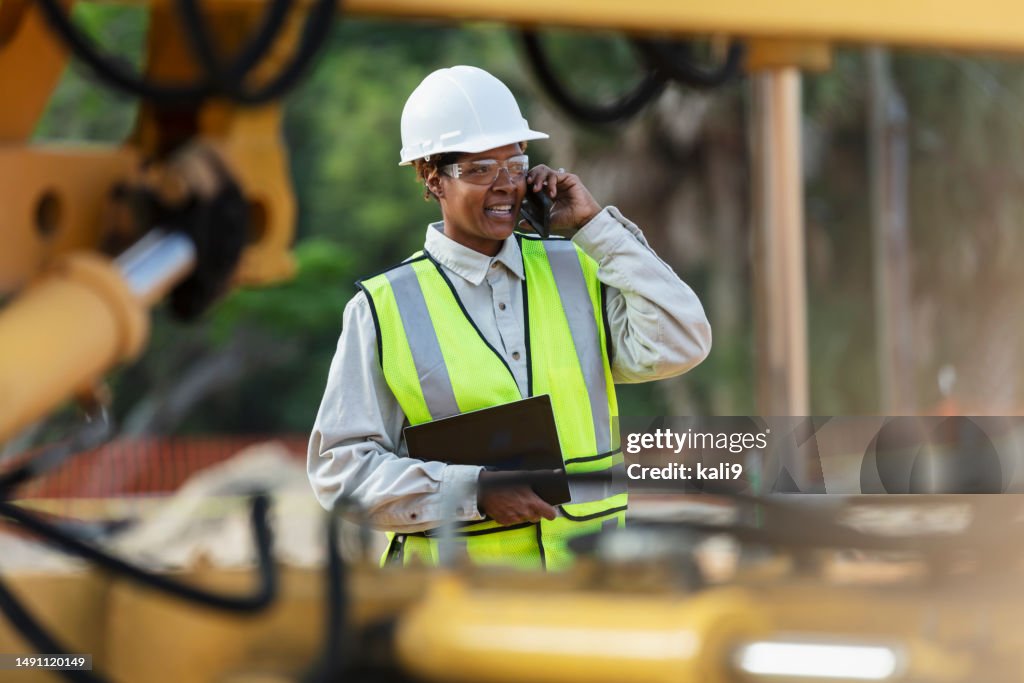 Trabalhadora afro-americana da construção civil no telefone celular