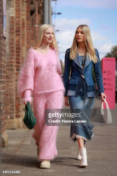 Guest wearing pink knit top and maxi skirt and a guest wearing blue denim jacket and maxi skirt and white bag and boot at Afterpay Australian Fashion...