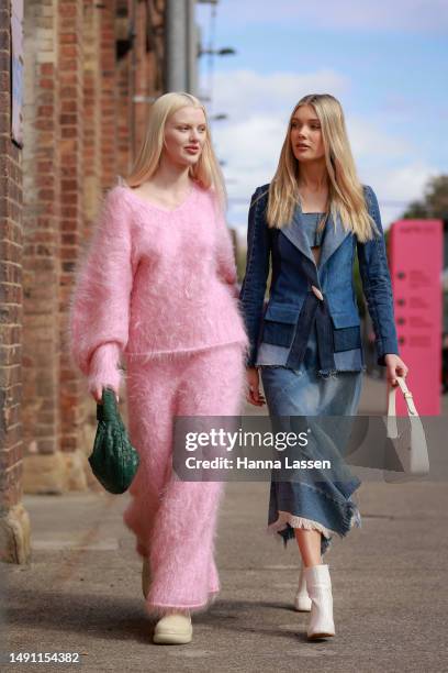 Guest wearing pink knit top and maxi skirt and a guest wearing blue denim jacket and maxi skirt and white bag and boot at Afterpay Australian Fashion...
