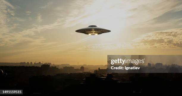 il disco volante ufo si librava silenziosamente sulla città - disco volante foto e immagini stock