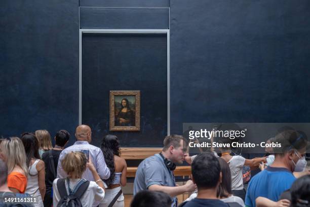 Visitors take picture of the painting "La Joconde" The Mona Lisa by Italian artist Leonardo Da Vinci on display in a gallery at The Louvre Museum in...