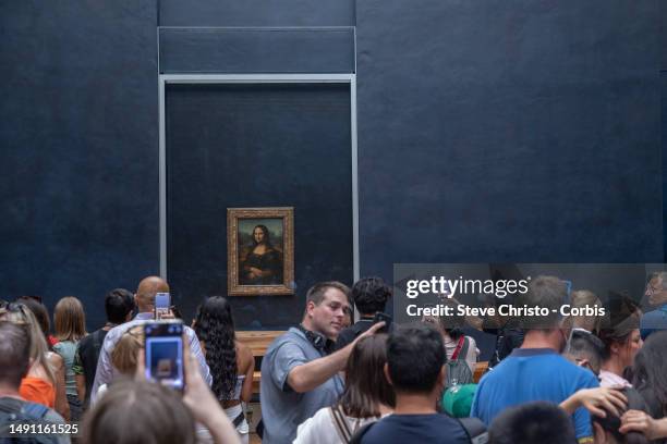 Visitors take picture of the painting "La Joconde" The Mona Lisa by Italian artist Leonardo Da Vinci on display in a gallery at The Louvre Museum in...