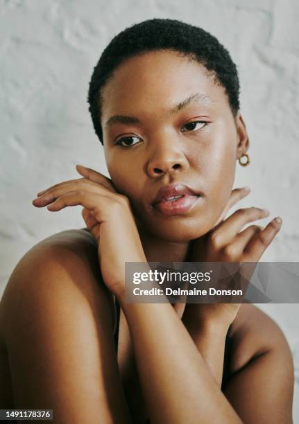 portrait shot of a beautiful black woman, looking away from the camera whilst her hands is crossed under her chin, stock photo - dark skin tone stock pictures, royalty-free photos & images