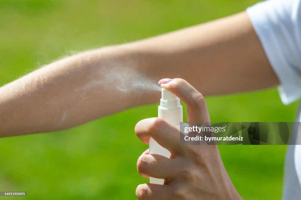 Woman spraying mosquito insect repellen