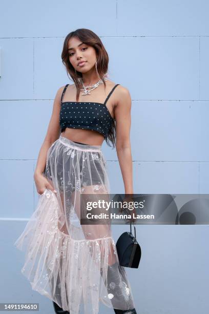 Guest wearing bra top, see through sheer white skirt and black knee high boots at Afterpay Australian Fashion Week 2023 at Carriageworks on May 18,...