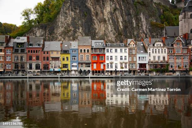 view of picturesque dinant town belgium. scenic view of lake by buildings and their reflections. - namur stock-fotos und bilder