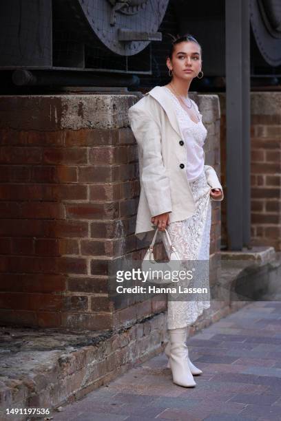 Guest wearing white jacket and white lace maxi dress at Afterpay Australian Fashion Week 2023 at Carriageworks on May 18, 2023 in Sydney, Australia.