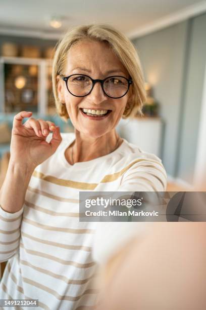 mujer madura caucásica que se toma selfie o realiza una videollamada con el teléfono móvil - selfie milan fotografías e imágenes de stock