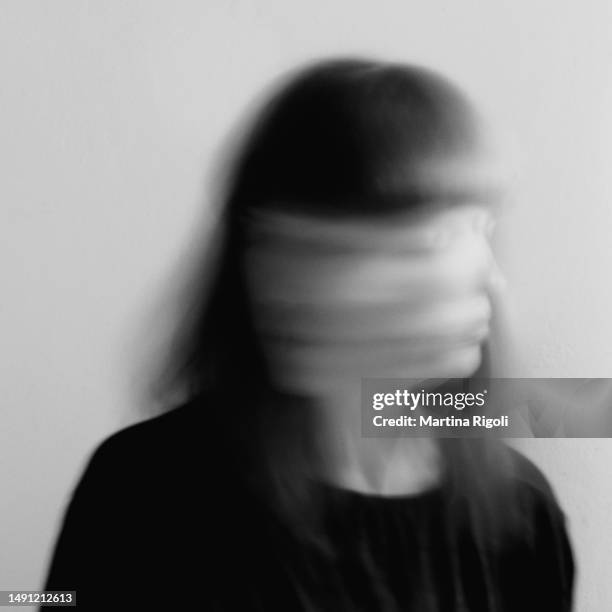 junge frau, die ihren kopf schnell bewegt, surreales schwarz-weiß-langzeitbelichtungsporträt - sad black and white portrait stock-fotos und bilder