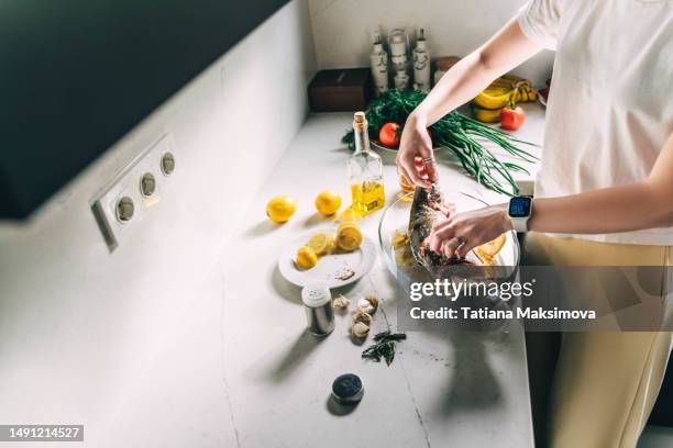 unrecognizable person marinates turkish salmon with lemon before grilling.unrecognizable person marinates turkish salmon with lemon before grilling. - frozen fish fillets stockfoto's en -beelden