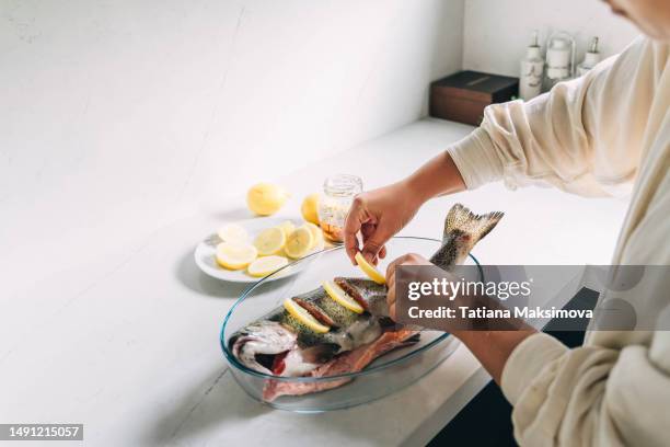 unrecognizable person marinates turkish salmon with lemon before grilling.unrecognizable person marinates turkish salmon with lemon before grilling. - frozen fish fillets stockfoto's en -beelden