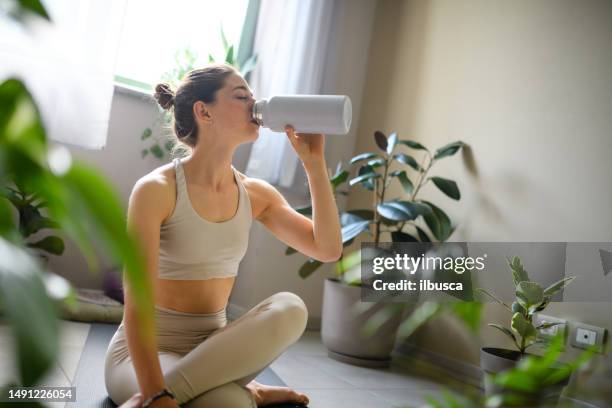 frau übt yoga zu hause - yoga kissen stock-fotos und bilder