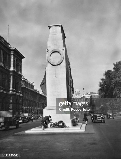 Woman lays a wreath at the base of the Cenotaph war memorial on Whitehall, London on 10th November 1945. The Cenotaph was designed by English...