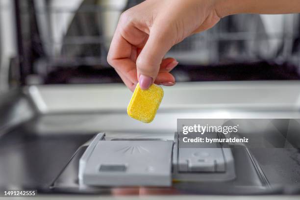 dishwashing tablet put into the appliance - dishwasher stock pictures, royalty-free photos & images