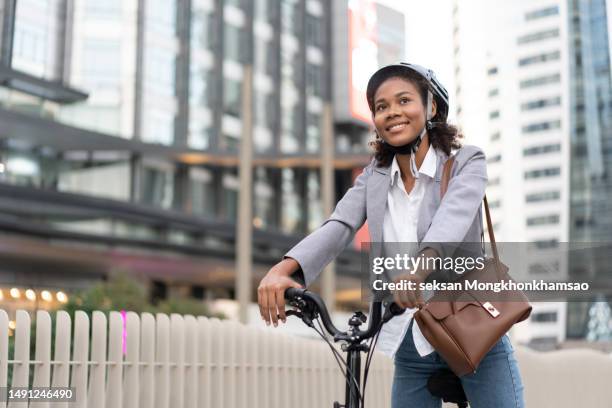 smiling businesswoman enjoying arriving to work by bicycle - classic press conference stock pictures, royalty-free photos & images