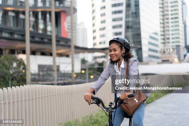 smiling businesswoman enjoying arriving to work by bicycle - classic press conference stock pictures, royalty-free photos & images