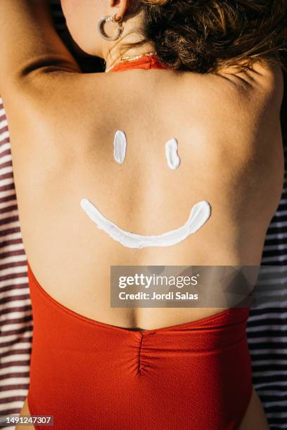 suntan lotion on a woman's back - beach sunbathing spain fotografías e imágenes de stock